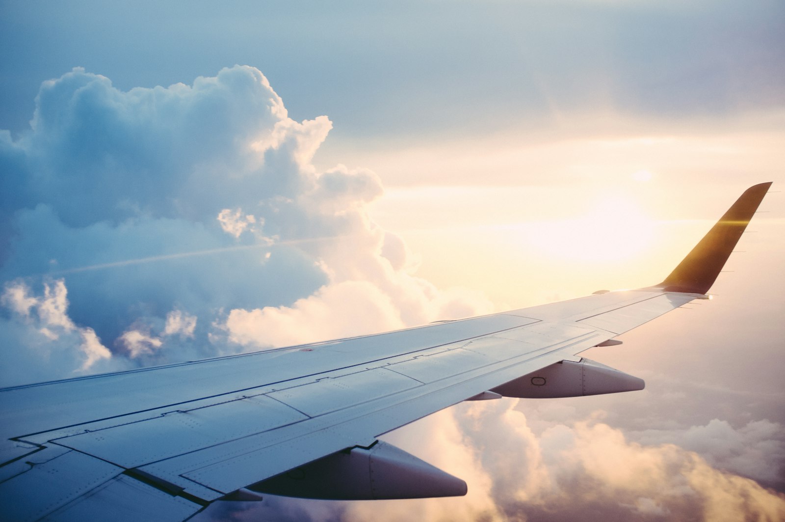 View of an aircraft wing above the clouds at sunset